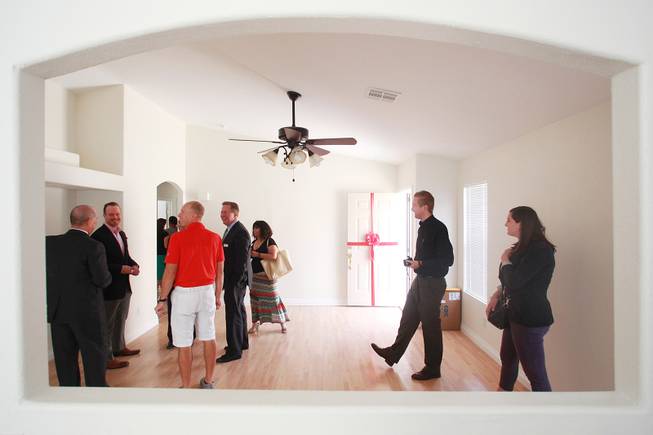 Representatives from Bank of America, Habitat for Humanity and public relations workers mill about after the presentation of a home to Denzi Watts and her three daughters Friday, May 9, 2014.