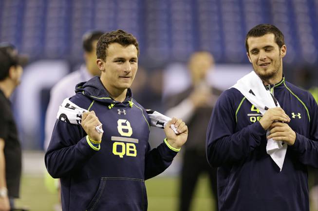 Texas A&M quarterback Johnny Manziel watches drills with Fresno State quarterback Derek Carr at the NFL football scouting combine in Indianapolis, Sunday, Feb. 23, 2014. ()