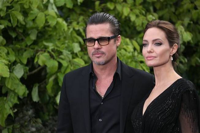 Actors Brad Pitt and Angelina Jolie arrive for the Maleficent exhibit in Kensington Gardens, London, Thursday, May. 8, 2014. The exhibit showcases some of the costumes and props from the film "Maleficent," before they go on display to the public at the O2 in London. 