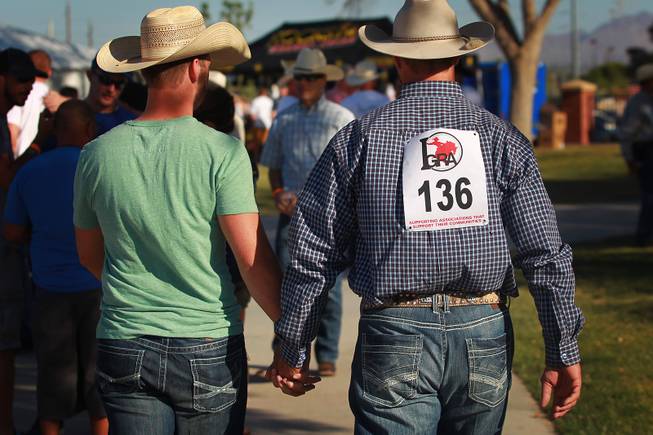 Two cowboys walk hand in hand during the Bighorn Rodeo Saturday, May 10, 2014. The Bighorn Rodeo is an annual event put on by the Nevada Gay Rodeo Association.