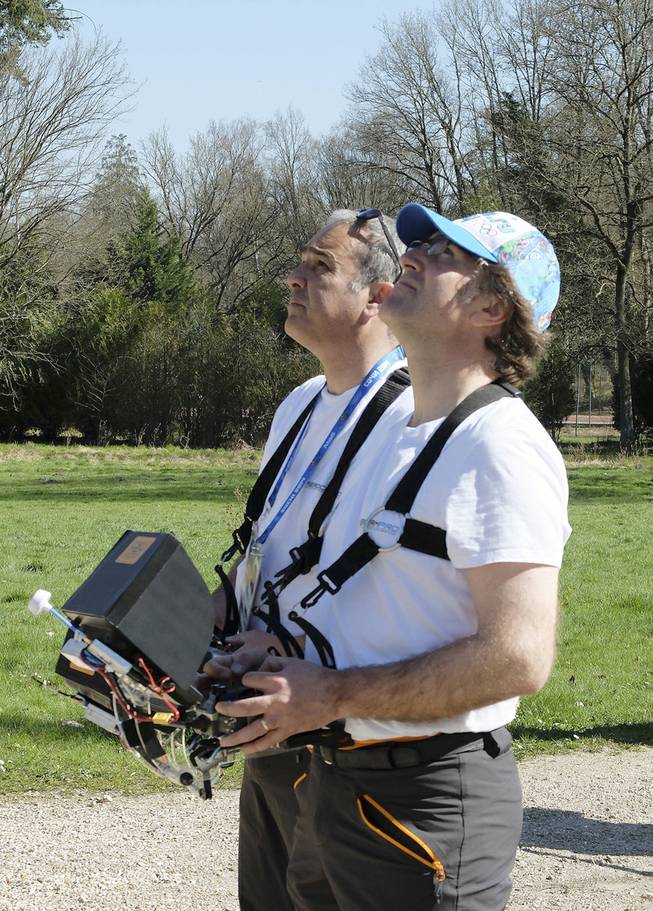 Drone operators Jean-Luc Fornier, left, and Philippe Delafosse control a drone at the Abbaye Des-Vaux-de-Cernay southwest of Paris, Thursday March 20, 2014. French drone operator Jean-Luc  Fornier operated the remote controlled drone used to used to transmit live video of snowboard and ski jump competitions at the Sochi Olympic Games. 