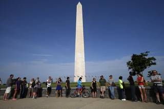 Visitors line up for tickets which are distributed at on a first-come basis at the Washington Monument in Washington, Monday, May 12, 2014, ahead of a ceremony to celebrate its re-opening. The monument, which sustained damage from an earthquake in August 2011, is reopening to the public today.