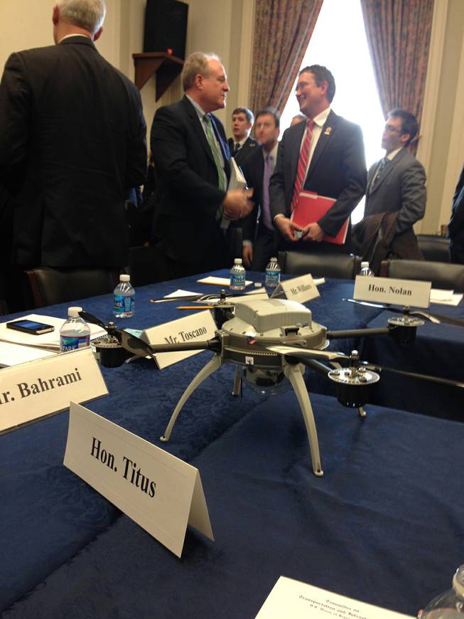 Members of the House Transportation and Infrastructure Committee get a close look at this four-rotor drone during a "roundtable discussion" meeting on Capitol Hill in Washington, Wednesday, March 5, 2014, with industry and Federal Aviation Administration (FAA) officials on how best to integrate small drones into the national airspace. 