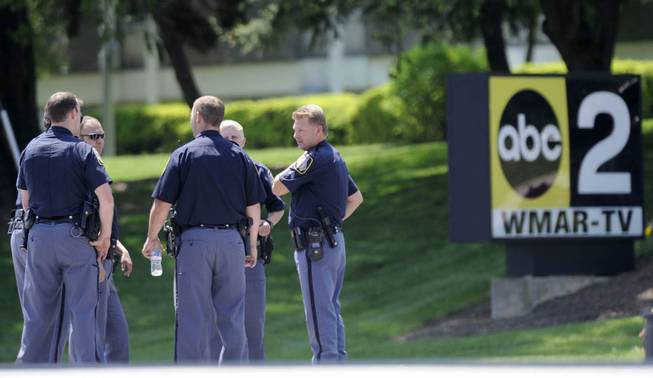 Police officers stand outside WMAR-TV, after a truck driven by a man rammed the Baltimore-area television station Tuesday, May 13, 2014 leaving a gaping hole in the front of the building, in Towson, Md.