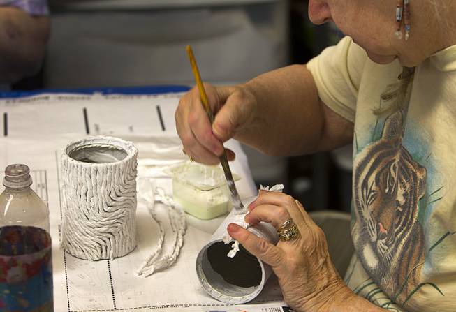 Volunteer Nancy David decorates a can during an art class at the Nevada Senior Services Adult Day Care Center of Las Vegas, 901 N. Jones Blvd., Wednesday, May 14, 2014. The artwork will be used as a menu holder at a restaurant.