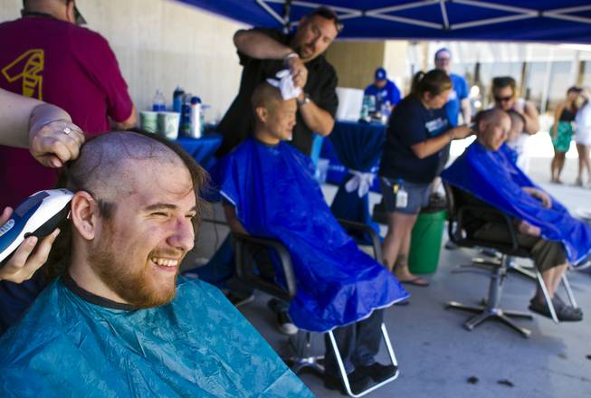 Zappos call center employee Robert Greeley joins others as they receive haircuts during the 10th Annual Zappos Bald and Blue charity event on Wednesday, May 15, 2014.
