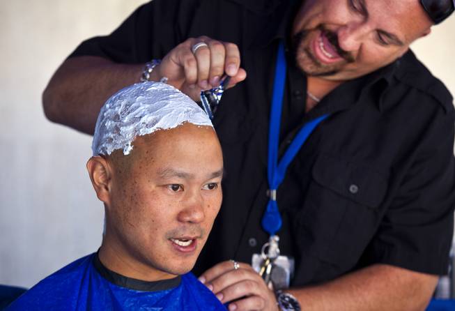 Zappos CEO Tony Hsieh has his head shaved by downtown community team member Loren Becker during the 10th Annual Zappos Bald and Blue charity event on Wednesday, May 15, 2014.