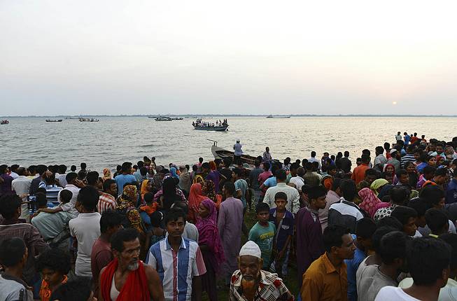 Bangladeshi people gather on the banks of the River Meghna after a ferry carrying more than 100 passengers capsized and sank after being hit by a storm in Munshiganj district, Bangladesh, Thursday, May 15, 2014. 