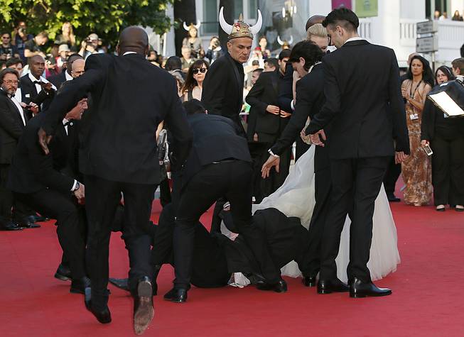 Security run toward an unidentified man who ran unauthorized onto the red carpet during arrivals for the screening of "How to Train Your Dragon 2" at the 67th Cannes International Film Festival in Cannes, France, on Friday, May 16, 2014. 