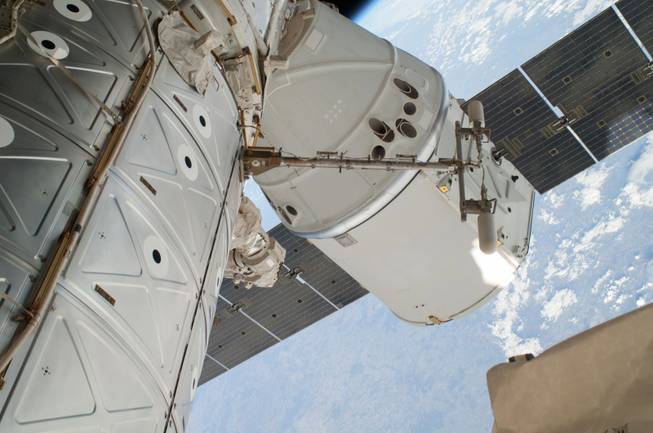This April 22, 2014 file photo provided by NASA shows a photo of the SpaceX Dragon spacecraft docked to the International Space Station and was photographed by one of two spacewalking astronauts. On Sunday, May 18, 2014, after a one-month visit, the SpaceX cargo ship was for return to Earth. The astronauts released it using the International Space Station’s big robot arm.