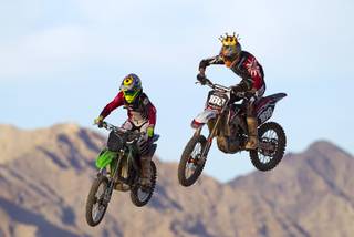 Eddie Chittock, left, 23, of Las Vegas, and Robert Slattery, 25, of Henderson fly off a jump at the Sandy Valley MX motocross course in Sandy Valley Thursday, May 15, 2014.