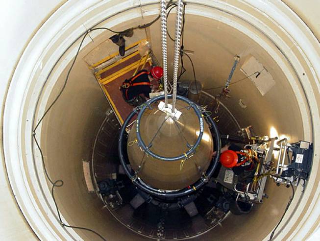 In this image released by the U.S. Air Force, a Malmstrom Air Force Base missile maintenance team removes the upper section of an ICBM at a Montana missile site.