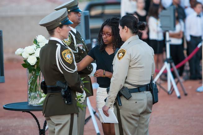 As the names of fallen officers are read, the family of fallen LVMPD Officer James L. Manor adds a white rose in his memory to the memorial bouquet during the Southern Nevada Law Enforcement Memorial ceremony at Police Memorial Park in Las Vegas Thursday, May 22, 2014.