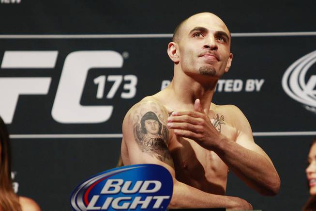 Chico Camus looks up and pats a tattoo of his deceased nephew after making weight during the weigh in for UFC 173 Friday, May 23, 2014 at the MGM Grand Garden Arena.