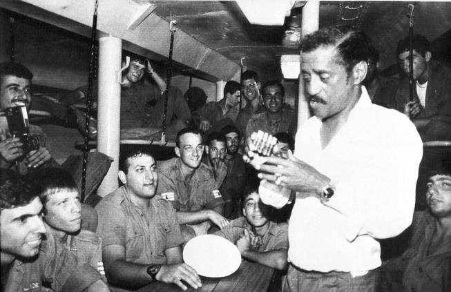 Entertainer Sammy Davis Jr is inspecting an ashtray made out of bullet cartridges which was given to him by Israeli missile boat crew which he visited in Northern Israel, July 14, 1982. 