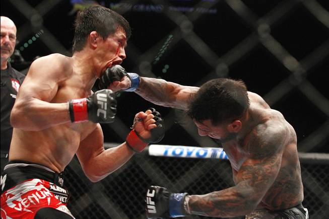Takeya Mizugaki is hit with a right from Francisco Rivera during their fight at UFC 173 Saturday, May 24, 2014 at the MGM Grand Garden Arena. Mizugaki won by unanimous decision.