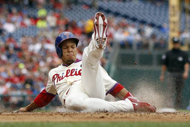 Philadelphia Phillies' Cesar Hernandez slides into home plate to score on a single by Ben Revere during the second inning of a baseball game against the Los Angeles Dodgers, Saturday, May 24, 2014, in Philadelphia.