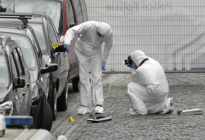 Forensic experts examine the site of a shooting at the Jewish museum in Brussels on Saturday, May 24, 2014. Belgian officials say that at least three people have been killed in gunfire at the Jewish Museum in Brussels.
