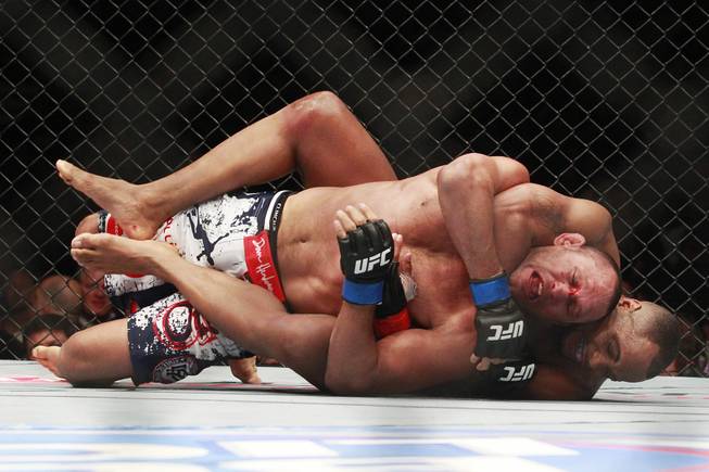 Daniel Cormier begins his winning choke of Dan Henderson during their fight at UFC 173 Saturday, May 24, 2014 at the MGM Grand Garden Arena. Cormier won with a rear naked choke in the third round.