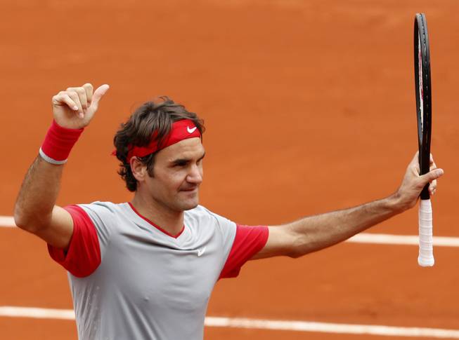 Switzerland's Roger Federer thumbs up after defeating Slovakia's Lukas Lacko in the first round match of the French Open tennis tournament at the Roland Garros stadium, in Paris, France, Sunday, May 25, 2014. Federer won 6-2, 6-4, 6-2. 