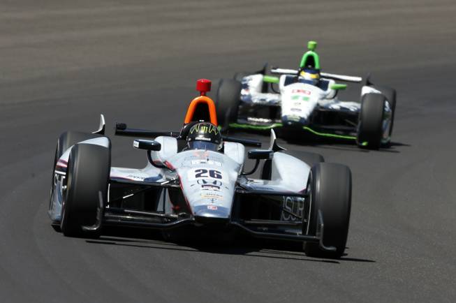 Kurt Busch (26) leads Sebastien Bourdais, of France, through the first turn during the 98th running of the Indianapolis 500 IndyCar auto race at the Indianapolis Motor Speedway in Indianapolis on Sunday, May 25, 2014.