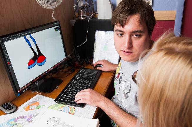 While creating the graphics for a new comic book, Ben Nelson, 20, talks with his mom, Laura, while working at his home in Henderson May 23, 2014.