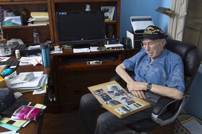 World War II veteran Davis B. Leonard looks through a photo album at his home in Henderson Wednesday, May 28, 2014. Leonard and Gaetano "Guy" Benza, another local World War II veteran, will receive the French Legion d'Honneur award on Friday. The award is the highest honor France bestows on its citizens and foreign nationals.