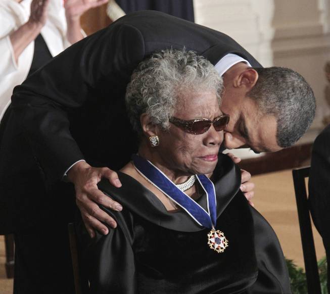 This Feb. 15, 2011 file photo shows President Barack Obama kissing author and poet Maya Angelou after awarding her the 2010 Medal of Freedom during a ceremony in the East Room of the White House in Washington. 