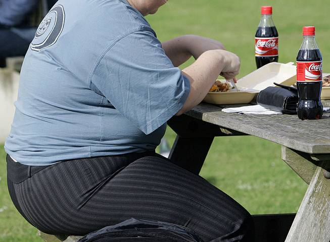 An overweight person eats in London. Almost one-third of the world population is now fat, and no country has been able to curb obesity rates in the last three decades, according to a global analysis released Thursday, May 29, 2014.