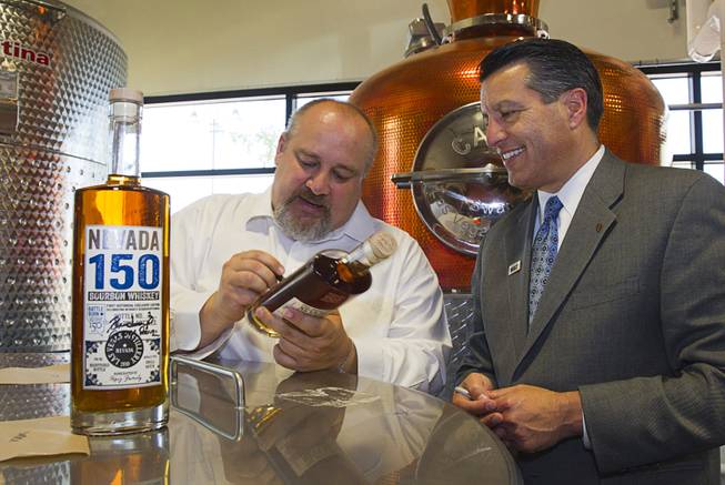 Distillery owner George Racz, left, and Nevada Governor Brian Sandoval autograph bottles of "Nevada 150" bourbon at the Las Vegas Distillery in Henderson Thursday, May 29, 2014. Governor Sandoval helped fill the first bottle of "Nevada 150," a bourbon whiskey created for the Nevada sesquicentennial.