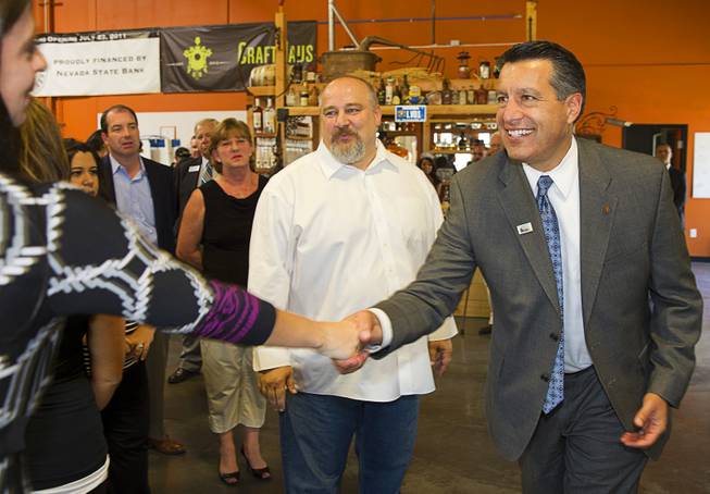 Nevada Governor Brian Sandoval, right, greets guests as he arrives at the Las Vegas Distillery in Henderson Thursday, May 29, 2014. Distillery owner George Racz looks on at center. Governor Sandoval helped fill the first bottle of "Nevada 150," a bourbon whiskey created for the Nevada sesquicentennial.