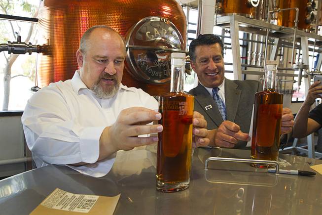 Distillery owner George Racz, left, and Nevada Governor Brian Sandoval put labels on bottles of whiskey at the Las Vegas Distillery in Henderson Thursday, May 29, 2014. Governor Sandoval helped fill the first bottle of "Nevada 150," a bourbon whiskey created for the Nevada sesquicentennial.