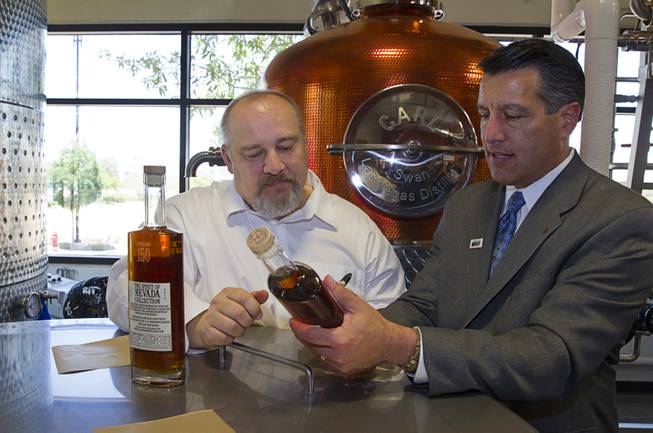 Nevada Governor Brian Sandoval, right, looks over a bottle of "Nevada 150" bourbon with distillery owner George Racz at the Las Vegas Distillery in Henderson Thursday, May 29, 2014. Governor Sandoval helped fill the first bottle of "Nevada 150," a bourbon whiskey created for the Nevada sesquicentennial.