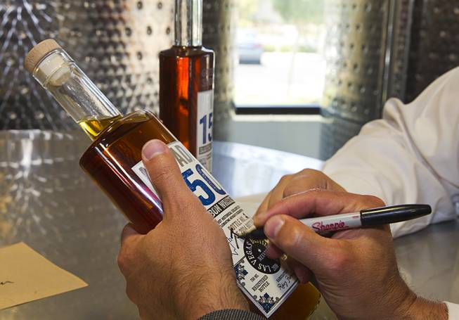 Nevada Governor Brian Sandoval signs a bottle of "Nevada 150" bourbon at the Las Vegas Distillery in Henderson Thursday, May 29, 2014. Governor Sandoval helped fill the first bottle of "Nevada 150," a bourbon whiskey created for the Nevada sesquicentennial.