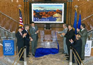 Invited dignitaries unveil the Nevada Sesquicentennial commemorative stamp as part of a United States Postal Service and Nevada Sesquicentennial Commission event at the Smith Center on Thursday, May 29, 2014.