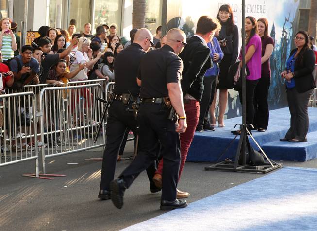 Journalist Vitalii Sediuk is walked off the carpet in handcuffs after allegedly attacking Brad Pitt at the world premiere of "Maleficent" at the El Capitan Theater on Wednesday, May 28, 2014, in Los Angeles. 