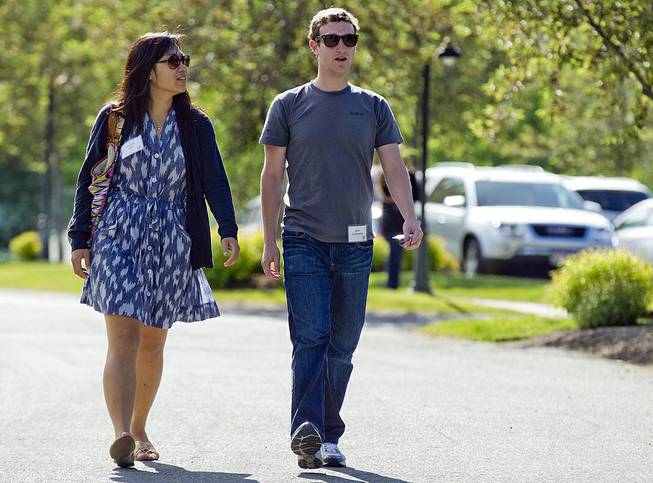 In this July 9, 2011, file photo, Mark Zuckerberg, president and CEO of Facebook, walks with Priscilla Chan during the 2011 Allen and Co. Sun Valley Conference in Sun Valley, Idaho. 