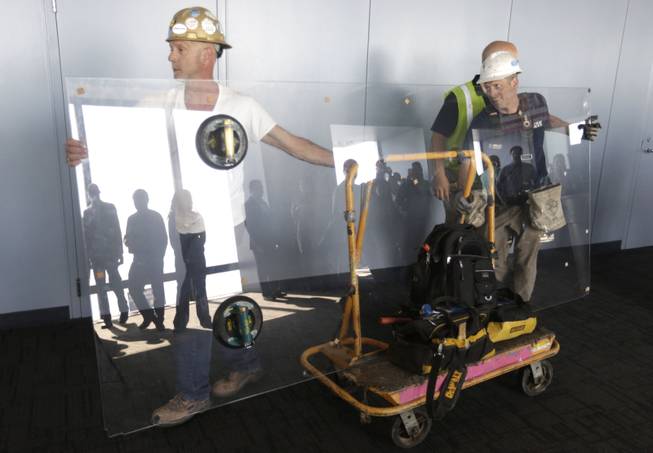 Glaziers from MTH Industries arrive to replace a layer of protective coating over the glass surface on the floor of one of four transparent ledges that jut out from the 103rd floor of the Willis Tower in Chicago on Thursday, May 29, 2014. 