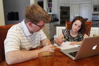 Ciara Swenson ponders a math problem with tutor Michael Christenson during a tutoring session in the Swenson's home Saturday, May 31, 2014.