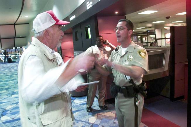 A man trying to locate his wife is denied passage to the gate area by Metro Police officer Frank Mandracchio at McCarran International Airport Tuesday, Sept. 11, 2001.