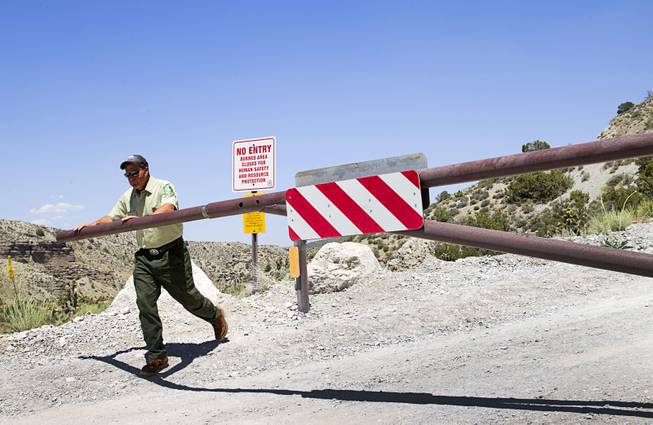 Ron Bollier, a USFS fire management officer, opens a gate on Harris Springs Road on Mt. Charleston Tuesday, May 27, 2014. The road is temporarily closed to the public to give burned areas a chance to recover.