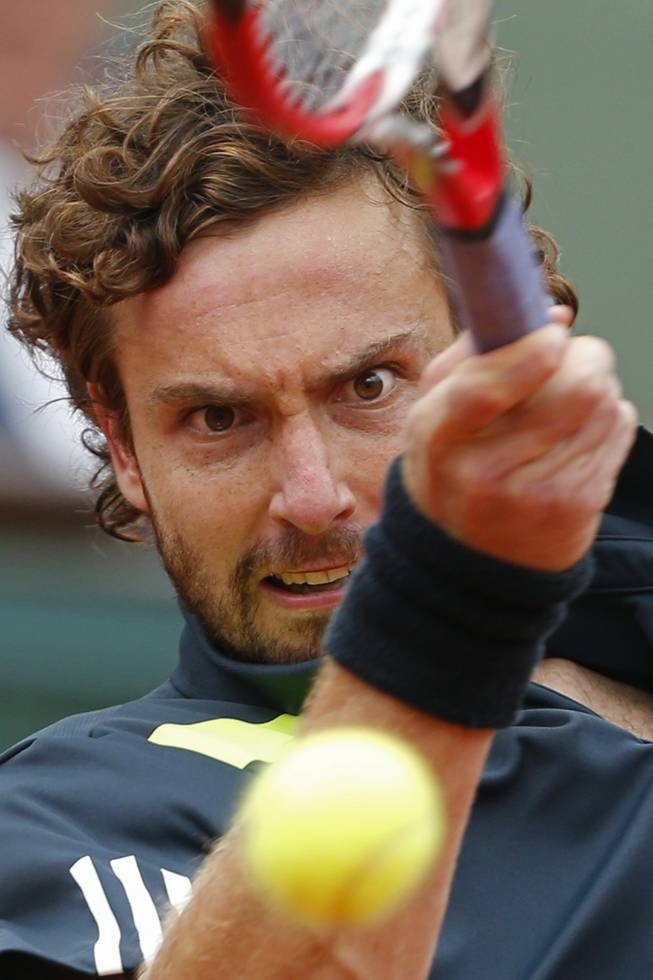 Latvia's Ernests Gulbis returns the ball during the fourth round match of the French Open tennis tournament against Switzerland's Roger Federer at the Roland Garros stadium, in Paris, France, Sunday, June 1, 2014. Gulbis won in five sets 6-7, 7-6, 6-2, 4-6, 6-3.