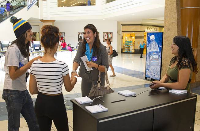 Lucy Flores, Democratic candidate for Lieutenant Governor, chats with shoppers after voting early at the Meadows Mall Monday, June 2, 2014. From left are: Brenda Osorio, Salvador Sanchez and Silvia Saenz. Early voting for the 2014 primary election continues through Friday June 6 at 83 sites.