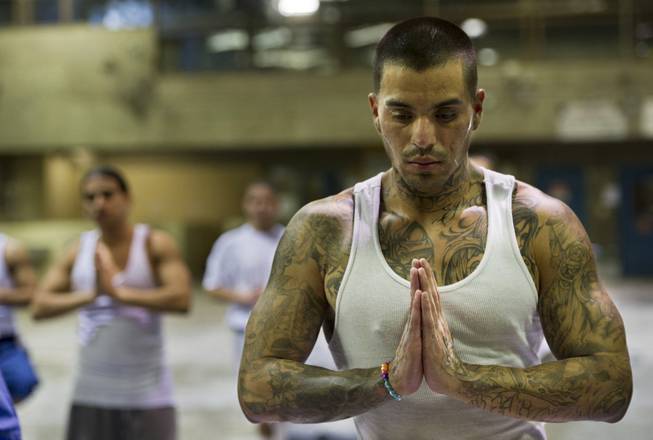 Carlos Perez, centers himself on "Nameste" during a yoga class for inmates at the California State Prison in Sacramento, Calif., on April 30, 2014, offered through the non-profit Yoga Seed Collective outreach program.