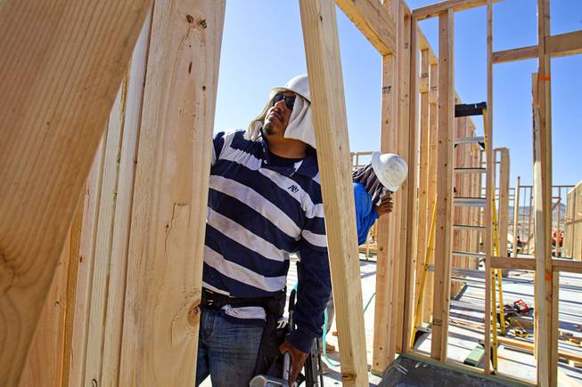 Carpenters work on a KB Homes project at Inspirada in Henderson Tuesday, June 3, 2014. A number of formerly stalled or financially troubled master-planned communities are now back in business, with developers building and selling homes.