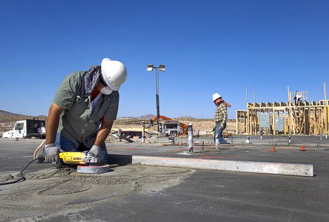 A worker grinds on a concrete slab at a KB Homes project at Inspirada in Henderson Tuesday, June 3, 2014. A number of formerly stalled or financially troubled master-planned communities are now back in business, with developers building and selling homes.