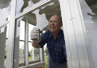 Lloyd Wright clears broken glass from his porch in Blair, Neb., Wednesday, June 4, 2014, following a severe storm that passed through the region the previous evening. 