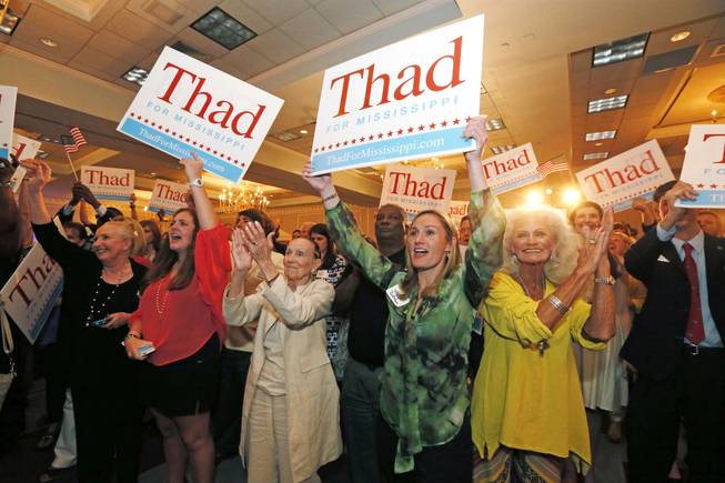 Supporters for U.S. Sen. Thad Cochran, R-Miss., cheer and wave signs as they wait for comments from his campaign staff, Tuesday, June 3, 2014, in Jackson, Miss.