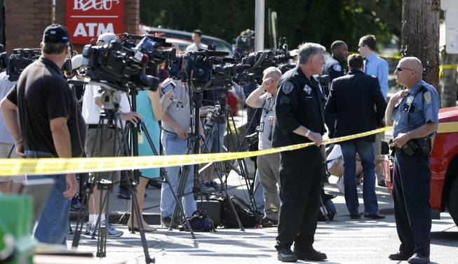 Television videographers and other media wait for a briefing at the scene of a shooting Thursday, June 5, 2014, at Seattle Pacific University in Seattle. (AP Photo/Ted S. Warren)