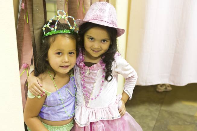 Reece, 3, and Mia, 5, pose for a photo after trying on some party costumes at Rock the Tea, Tuesday June 3, 2014. Rock the Tea is a themed party-hosting service for young girls.